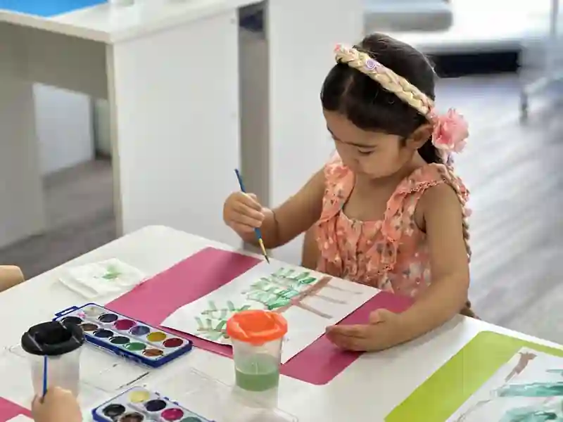 A child concentrating on a watercolor painting activity