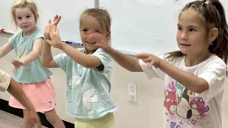 Children smiling and moving together during a group activity