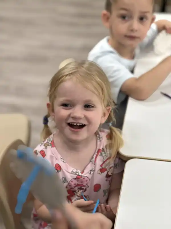 A smiling child enjoying a classroom activity