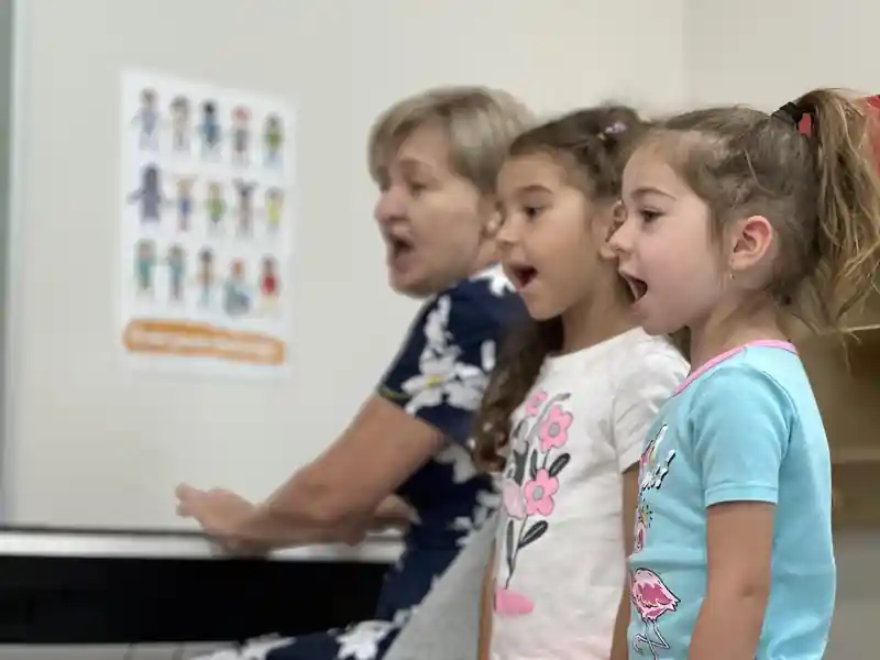 Children singing with a teacher during music time