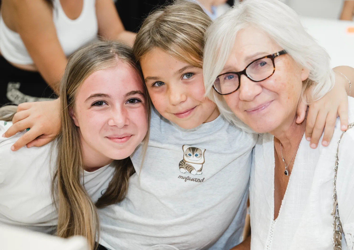 Two children and a caring adult smiling together in the classroom